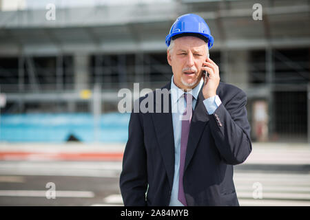 Ritratto di un architetto di parlare al telefono con il suo contraente Foto Stock