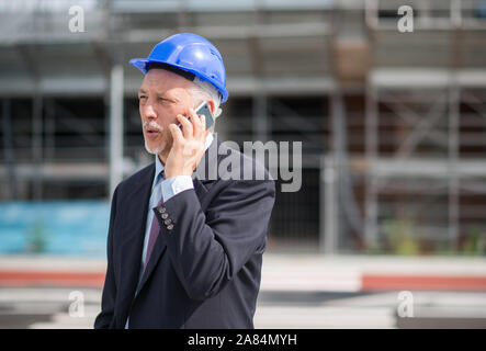 Ritratto di un architetto di parlare al telefono con il suo contraente Foto Stock