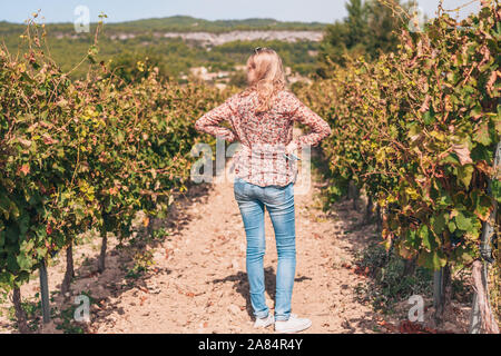 Gordes, Vaucluse/Francia - 25 Settembre 2018: attraente trendy biondo carino ispeziona un vigneto Foto Stock