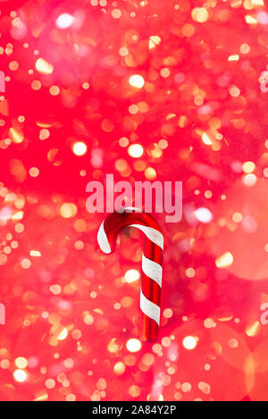 Albero di Natale Decorazioni realizzate in forma di vetro Candy Canes su sfondo rosso, vista dall'alto, copia spazio, bokeh con luci sullo sfondo Foto Stock