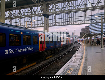 Un Sud Occidentale stazione ferroviaria in attesa presso la piattaforma presso la stazione di Waterloo. Foto Stock