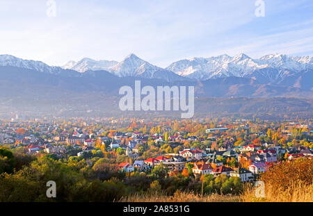 Vista panoramica della parte superiore di Almaty città sullo sfondo di montagne in autunno; golden caduta, la bellezza e la grandezza del Kazakistan conce Foto Stock