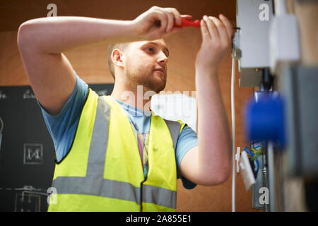 Elettricista maschio studente utilizzando un cacciavite Foto Stock