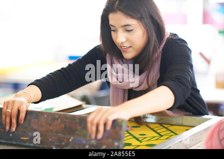 Artista femminile la stampa serigrafica in art studio Foto Stock