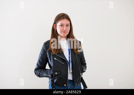 Ritratto fiducioso giovane donna indossando giacca di pelle Foto Stock