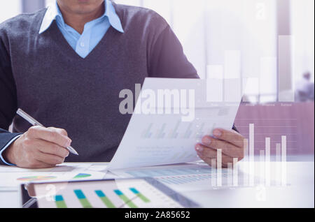 Imprenditore o contabile che lavora in ufficio la revisione dei rendiconti finanziari per prestazioni aziendali periodicamente. Foto Stock