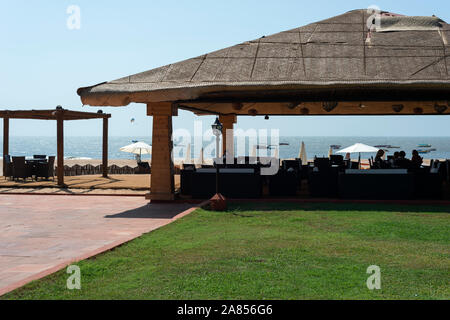 Scattato dalla stanza del giardino, prato, ristorante, bar, mare, ombrelloni a esclusivo resort di lusso. La Calypso, Baga Beach, Goa, India. Foto Stock