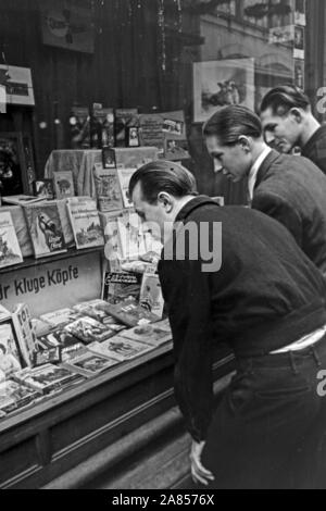 Die Gefangenen schauen era es così im Schaufenster zu kaufen gibt, Justizvollzugsanstalt Herford Deutschland 1950. Alcuni detenuti sono guardando ciò che la vetrina del negozio ha da offrire, correttivi facility Herford Germania 1950. Foto Stock