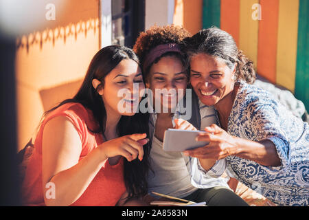 Felice la madre e le figlie tenendo selfie con smart phone Foto Stock