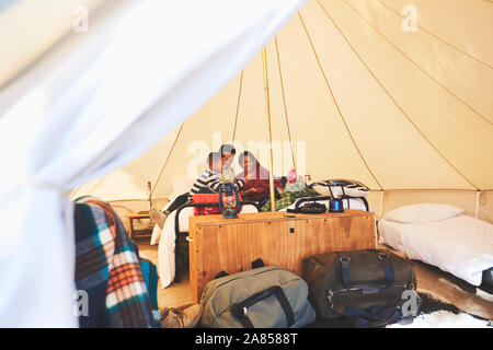 Famiglia rilassante sul letto all'interno del camping yurt Foto Stock