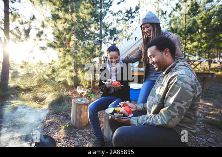 Happy amici di mangiare al campeggio di sole Foto Stock