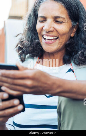 Sorridente, donna felice utilizzando smart phone Foto Stock