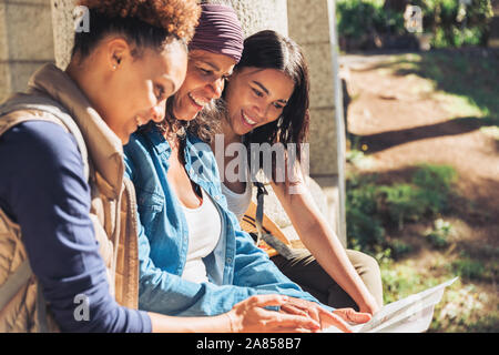 Madre e figlia escursionisti guardando la mappa in boschi di sole Foto Stock