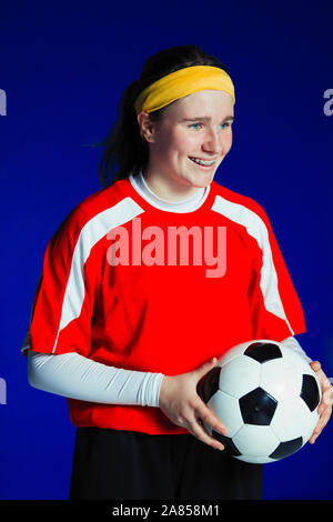 Ritratto sorridente ragazza adolescente soccer giocatore in possesso palla Foto Stock