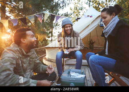 Gli amici a giocare a carte in campeggio Foto Stock