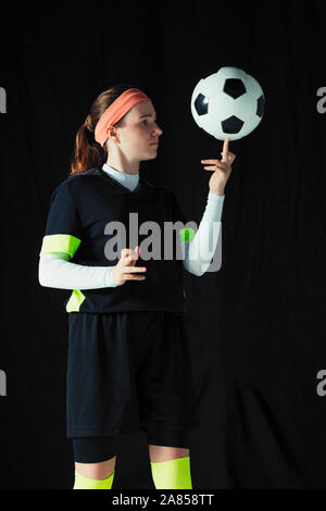 Ragazza adolescente giocatore di calcio calcio di bilanciamento palla sul dito Foto Stock