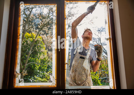 Pittore maschio pittura home esterno del rivestimento del vetro Foto Stock
