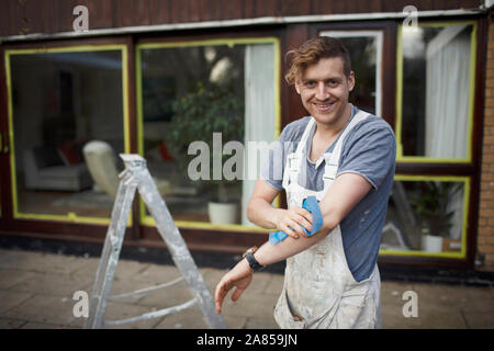 Ritratto fiducioso pittore maschio fuori casa Foto Stock