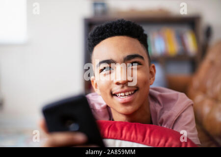 Sorridente ragazzo adolescente con smart phone Foto Stock