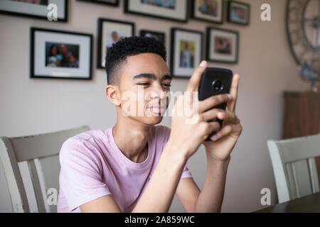 Ragazzo adolescente utilizzando smart phone Foto Stock