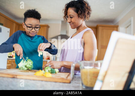 Madre e Figlio la cottura tagliare le verdure in cucina Foto Stock