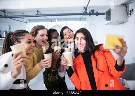 Felice imprenditrici celebrando, tenendo selfie Foto Stock