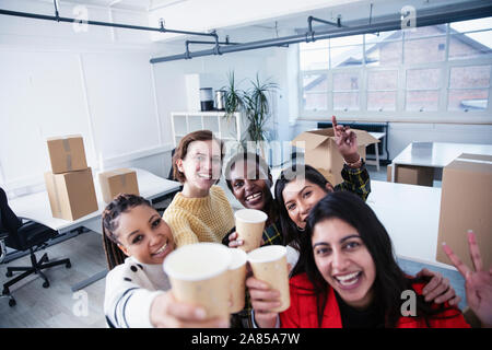 Ritratto felice imprenditrici che celebra un nuovo ufficio Foto Stock