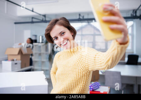 Fiducioso imprenditrice tenendo selfie nel nuovo ufficio Foto Stock