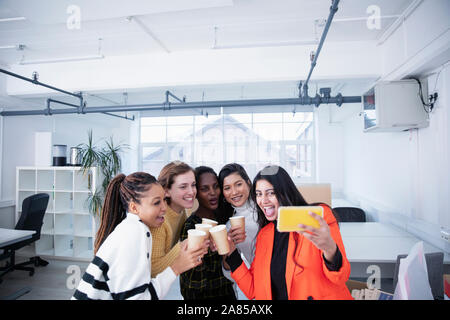 Imprenditrici che celebra un nuovo ufficio, tenendo selfie Foto Stock