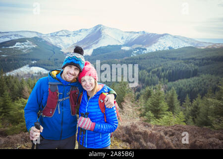 Ritratto felice coppia trekking panoramico con vista sulle montagne in background, Lake District, REGNO UNITO Foto Stock