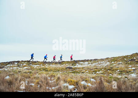 Amici jogging remote, sentiero innevato Foto Stock