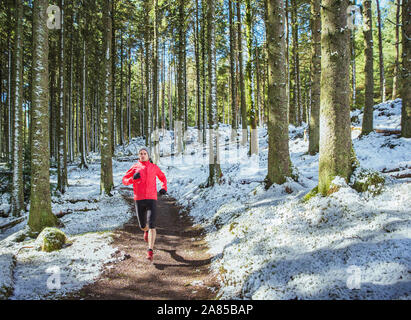 Uomo di jogging sul sentiero in nevoso, boschi remoti Foto Stock