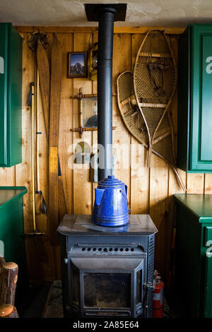 Smalto blu bollitore su piccolo nero stufa a legna in sala da pranzo camino  con pali di legno di innesco su cestelli Foto stock - Alamy