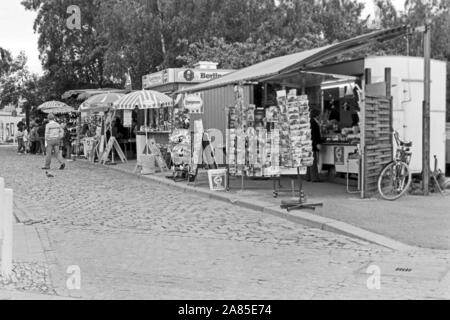 Andenkenläden und Erfrischungsstände machen das grosse Geschäft mit Touristen, die von der Aussichtsplattform am Potsdamer Platz di Berlino einen Blick in den Ostteil der Stadt werfen, Deutschland 1984. Negozi di souvenir e chioschi bisogno di denaro dai turisti che hanno un look da una piattaforma di osservazione a est di Berlino, Germania 1984. Foto Stock