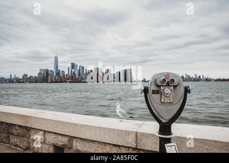 Gettoniera binocolo affacciato sullo skyline di New York City e per il porto. Foto Stock