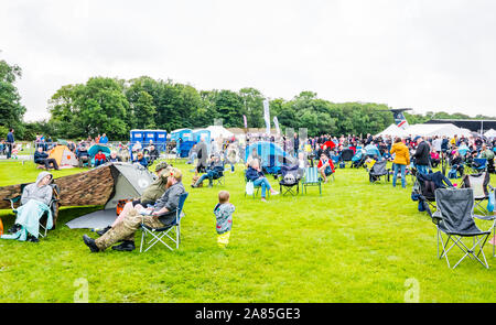 Gli spettatori seduti nel ripiegare su sedie in un giorno di pioggia a livello nazionale, airshow East Fortune, East Lothian, Scozia, Regno Unito Foto Stock