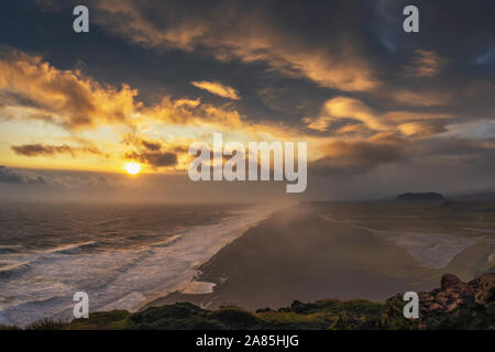 Tramonto spettacolare al di sopra di una spiaggia nera visto dal punto di vista Dyrholaey in Islanda Foto Stock