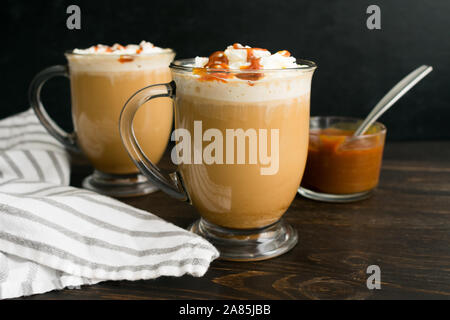 Caramello Brûlée caffè in tazze di vetro: caffè con latte conditi con panna montata e salsa di caramello Foto Stock