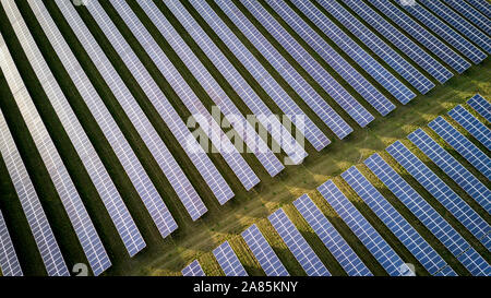 Angolo di alta vista di pannelli solari su una fattoria di energia in Inghilterra rurale; full frame texture di sfondo. Foto Stock