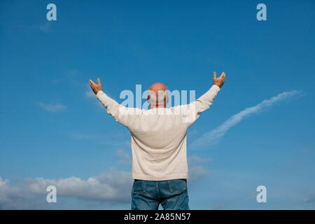 Vista posteriore del senior man tenendo le braccia in alto Foto Stock