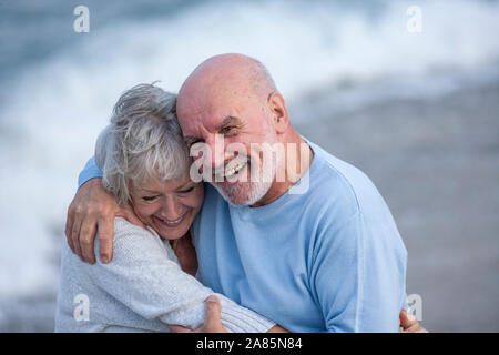 Coppia senior camminando lungo la riva Foto Stock