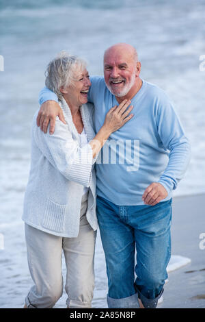 Coppia senior camminando lungo la riva Foto Stock