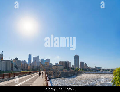 Minneapolis, MN. Lo skyline del centro cittadino dall'arco in pietra con Bridge St Anthony Falls a destra del fiume Mississippi, Minneapolis, Minnesota, Stati Uniti d'America Foto Stock