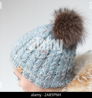 Piuttosto giovane donna che indossa un cappello con il POM Foto Stock
