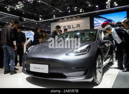 (191106) -- Shanghai, nov. 6, 2019 (Xinhua) -- persone di visualizzare un modello di Tesla 3 presso l'Automobile area espositiva durante la seconda China International Import Expo (CIIE) a Shanghai in Cina orientale, nov. 6, 2019. Il National Exhibition and Convention Centre di Shanghai ha salutato un gran numero di visitatori durante la seconda giornata del CIIE. (Xinhua/Ding Ting) Foto Stock