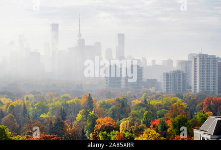 Lo skyline di Toronto in autunno con i colori di primo piano e di mattina nebbia e nuvole nel cielo. Foto Stock