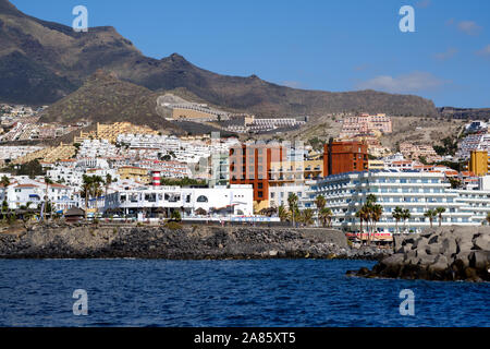 Tenerife, Spagna - 15 ottobre 2019: Waterside distante vista turistica località Los Cristianos, situato sulla costa meridionale delle Isole Canarie, Spagna Foto Stock