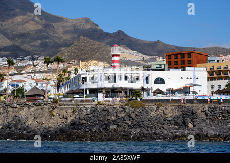 Tenerife, Spagna - 15 Ottobre 2019: Waterside veduta distante Los Cristianos costa, affollato lungomare Promenade street, città turistica, Spagna Foto Stock