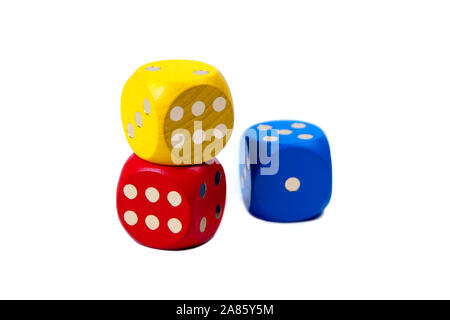 Tre dadi di gioco colorati accatastati, due di loro che mostrano sei e uno che mostra uno isolato su sfondo bianco. Sei e uno, contrasto, più e meno Foto Stock