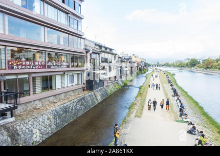 Kyoto, Japan - October 27th, 2019: People enjoying a sunny autumn day along the Kamo River. Foto Stock